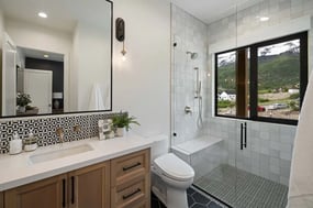 Custom luxury bathroom featuring a walk-in shower with a built-in bench by E Builders in Utah