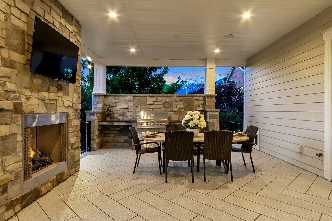 Covered outdoor dining and grilling space of a custom home by E Builders featured in the 2019 Utah Valley Parade of Homes
