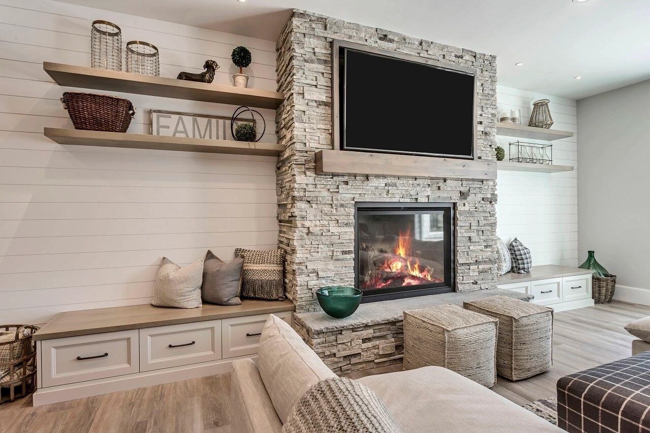 Cozy family room with fireplace and stone surround in a custom home by E Builders featured in the 2019 Utah Valley Parade of Homes