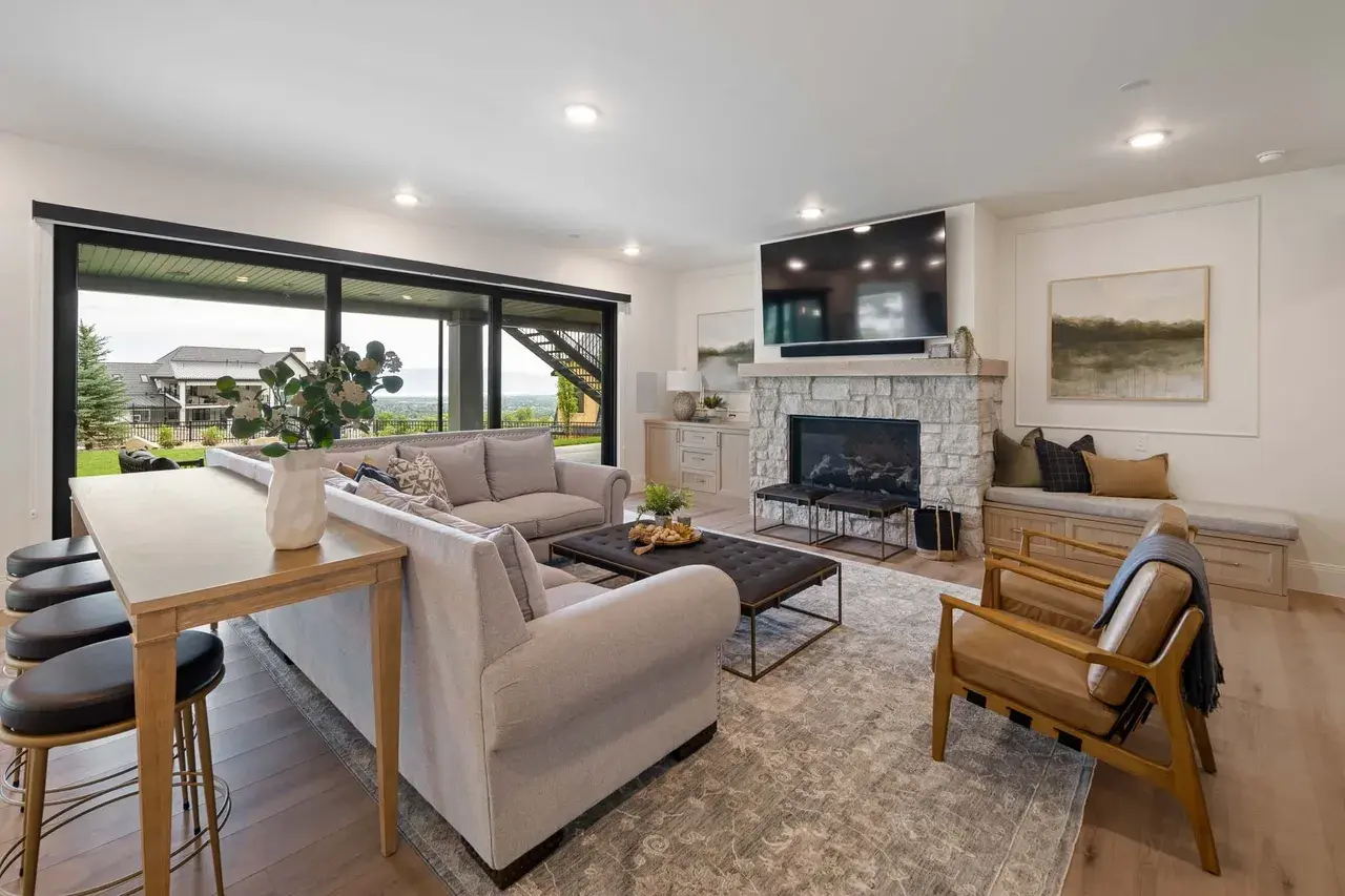 Basement family room with stone fireplace in a custom home in Utah Valley by E Builders
