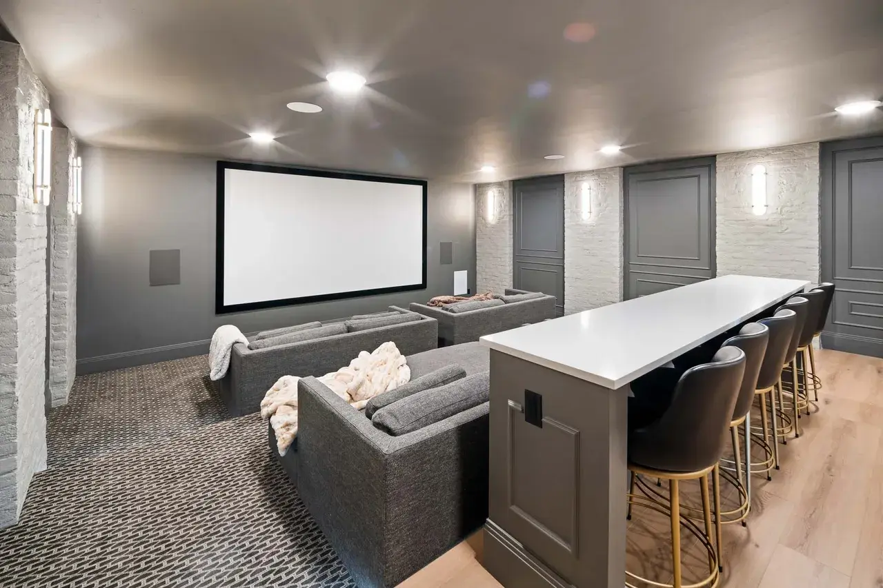 Basement home theater with bar seating in a custom home in Utah Valley by E Builders