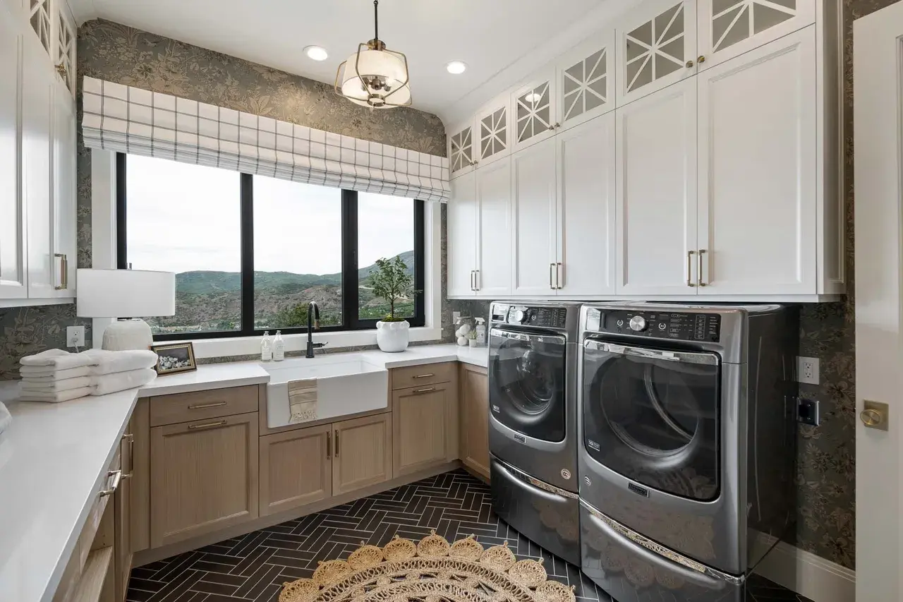 Bright and spacious laundry room with black appliances in a custom home in Utah Valley by E Builders
