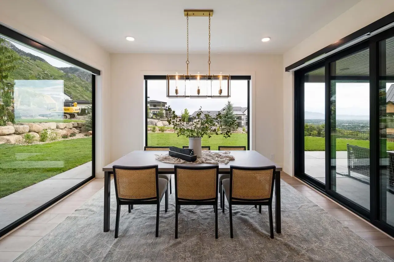 Bright dining area with panoramic windows in a custom home in Utah Valley by E Builders