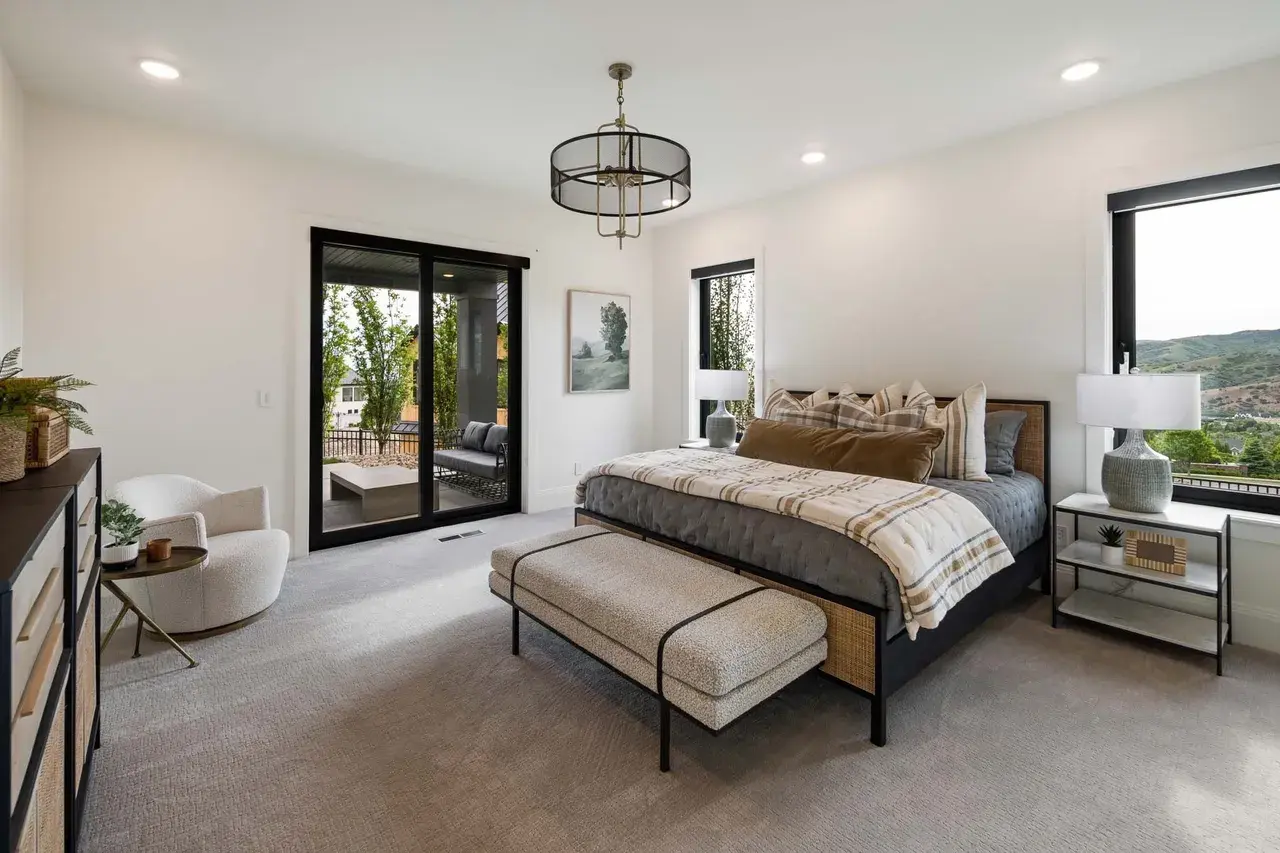 Contemporary bedroom suite with neutral tones in a custom home in Utah Valley by E Builders