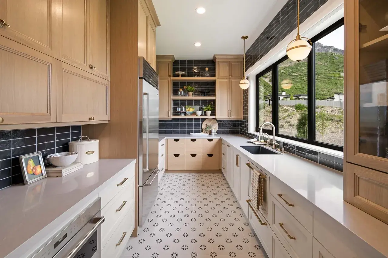 Custom kitchen with light wood cabinets and black tile in a custom home in Utah Valley by E Builders
