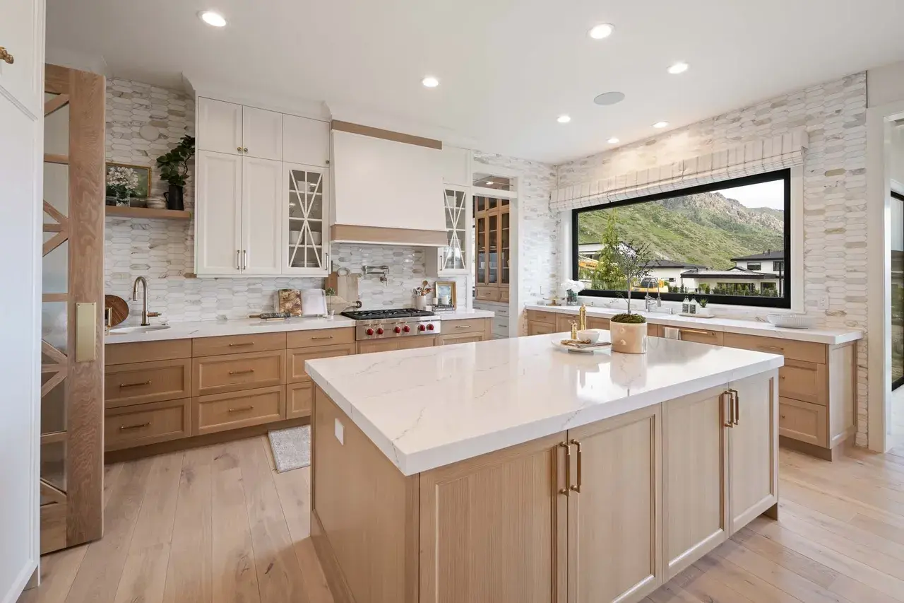 Custom kitchen with light wood cabinets and quartz countertops in a custom home in Utah Valley by E Builders