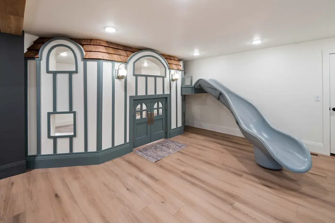 Custom-built children’s playhouse with slide in a custom home in Utah Valley by E Builders