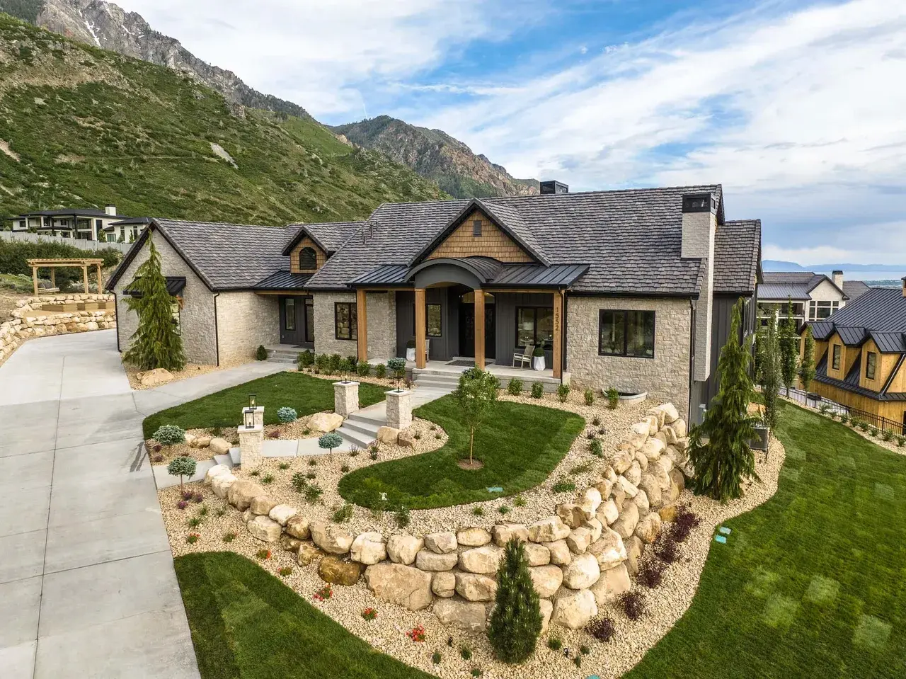 Elevated front landscape and stone façade in a custom home in Utah Valley by E Builders
