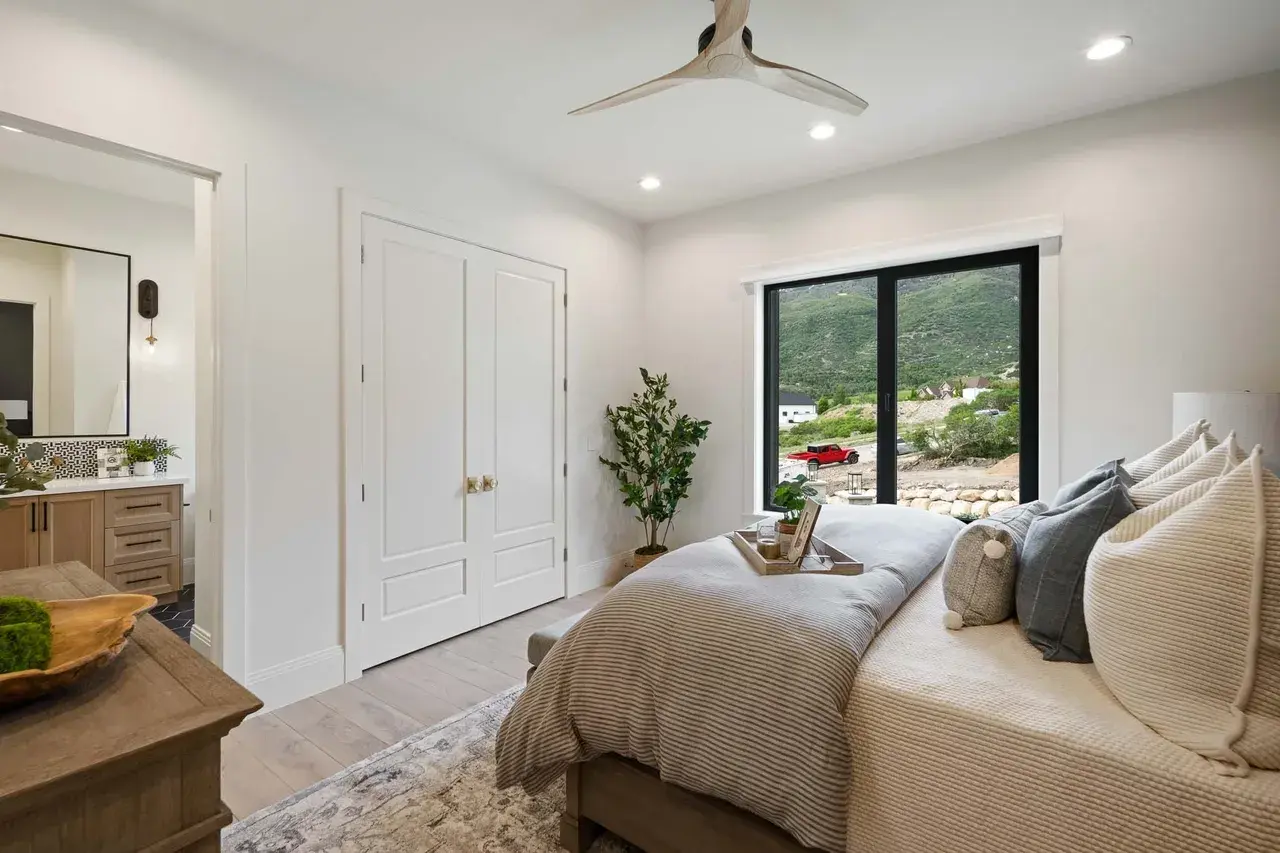 Guest bedroom with mountain views in a custom home in Utah Valley by E Builders
