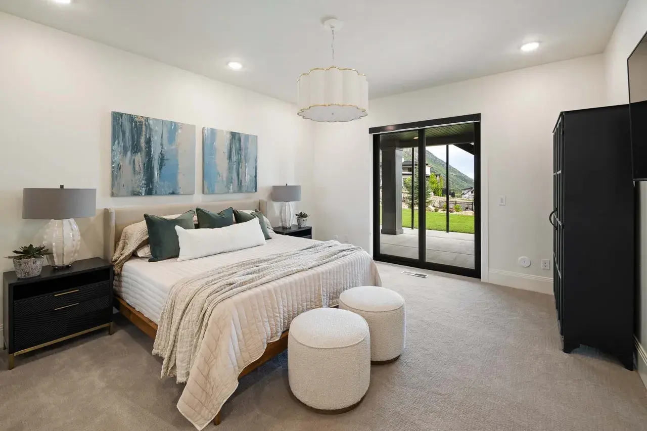 Guest bedroom with patio access in a custom home in Utah Valley by E Builders