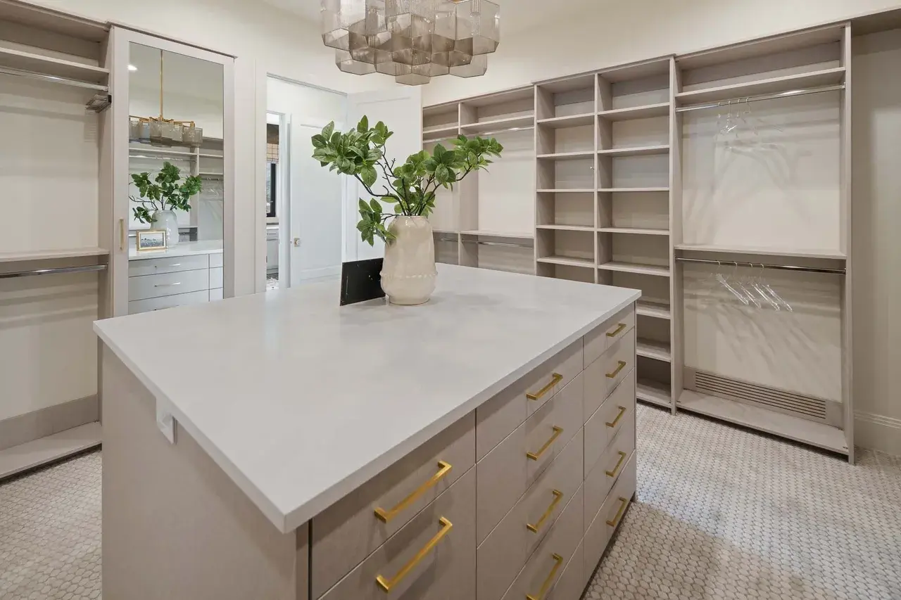 Luxurious walk-in closet with island and shelving in a custom home in Utah Valley by E Builders
