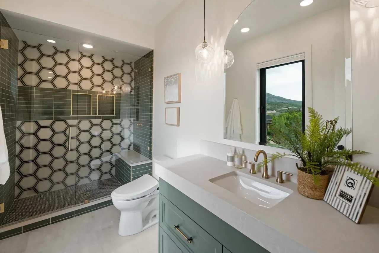 Modern bathroom with gold accents and mountain view in a custom home in Utah Valley by E Builders