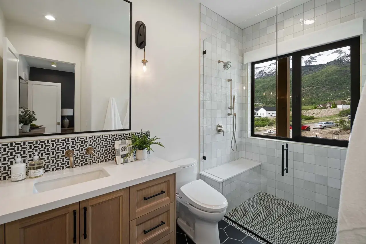 Neutral bathroom design with bold black tile in a custom home in Utah Valley by E Builders