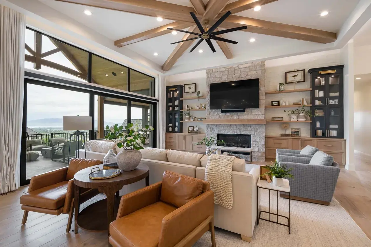 Vaulted ceiling living room with stone fireplace in a custom home in Utah Valley by E Builders