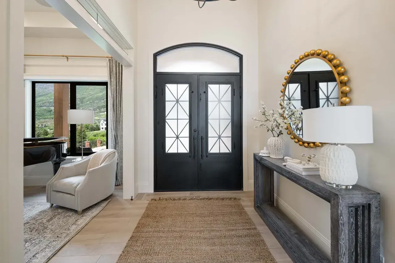 Welcoming entryway with double doors and designer console in a custom home in Utah Valley by E Builders