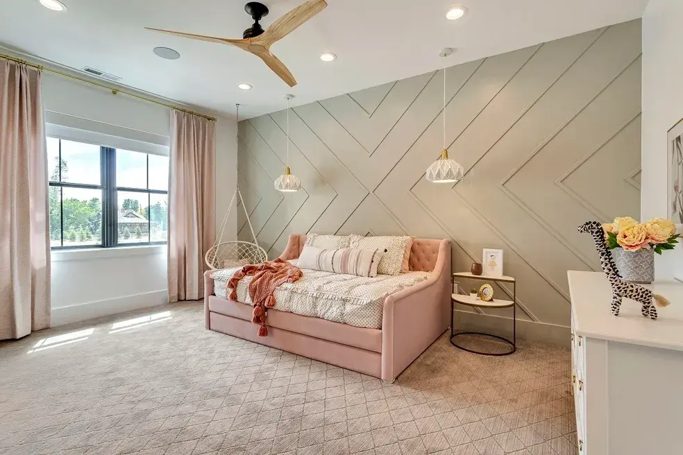Chic bedroom design with soft pink tones, textured walls, and gold-accented lighting in a custom home by E Builders, highlighted in the 2020 Utah Valley Parade of Homes