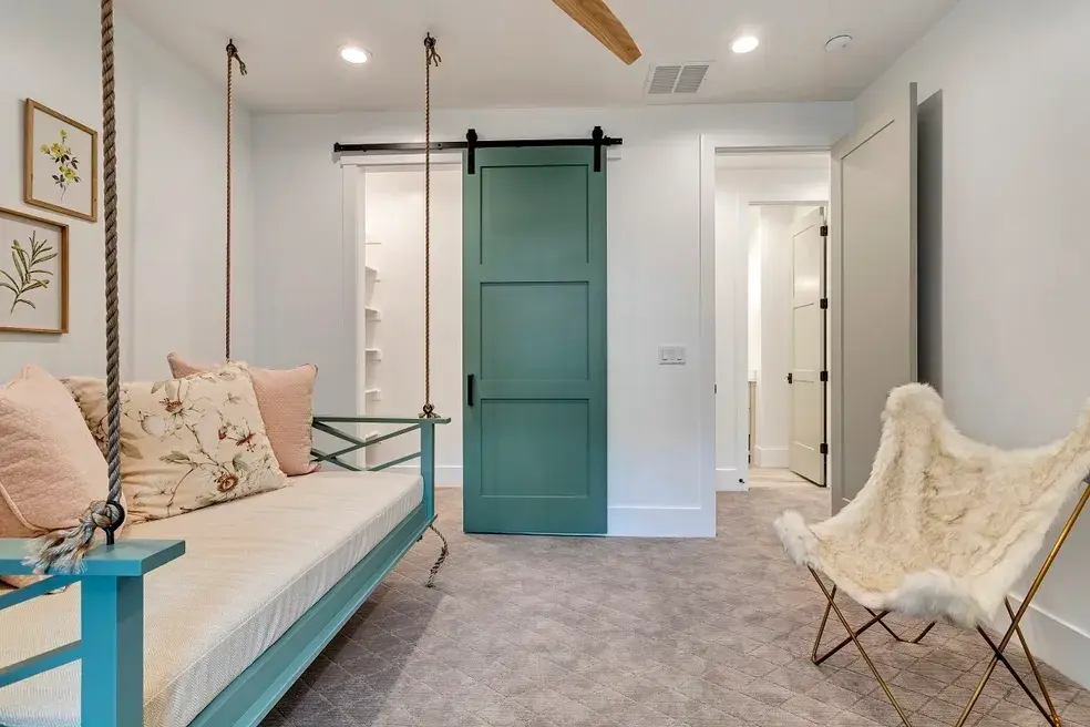 Cozy nook with a green barn door and a rope-suspended swing bench in a custom home by E Builders, featured in the 2020 Utah Valley Parade of Homes