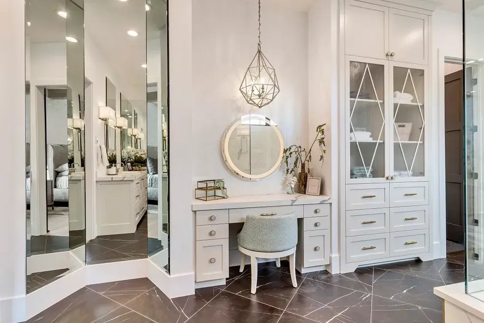 Elegant vanity area with a white dressing table, geometric pendant light, and mirrored wall accents in a custom home by E Builders, featured in the 2020 Utah Valley Parade of Homes
