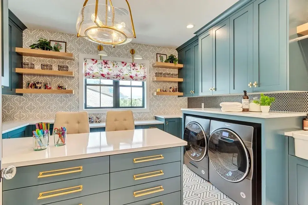 Functional and stylish laundry room with blue cabinets, a large work island, and gold accents in a custom home by E Builders, highlighted in the 2020 Utah Valley Parade of Homes