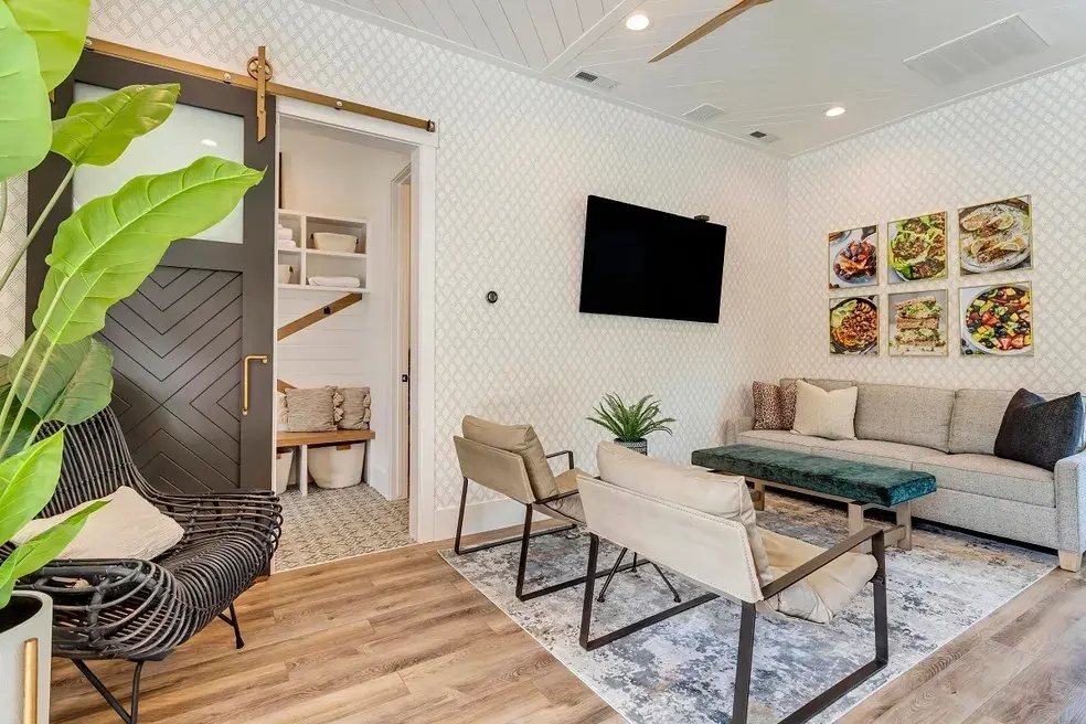 Modern living space with a black barn-style sliding door, elegant decor, and neutral furnishings in a custom home by E Builders, featured in the 2020 Utah Valley Parade of Homes