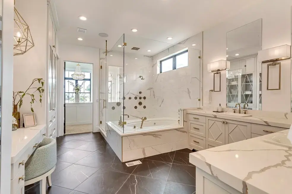 Spacious master bathroom with marble countertops, a glass-enclosed shower, and modern lighting in a custom home by E Builders, featured in the 2020 Utah Valley Parade of Homes