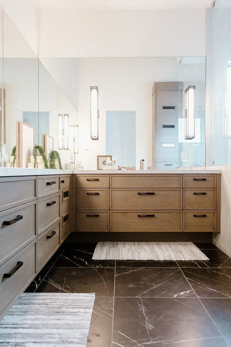Modern bathroom vanity with light wood cabinetry and black hardware in a contemporary custom home in Utah by E Builder