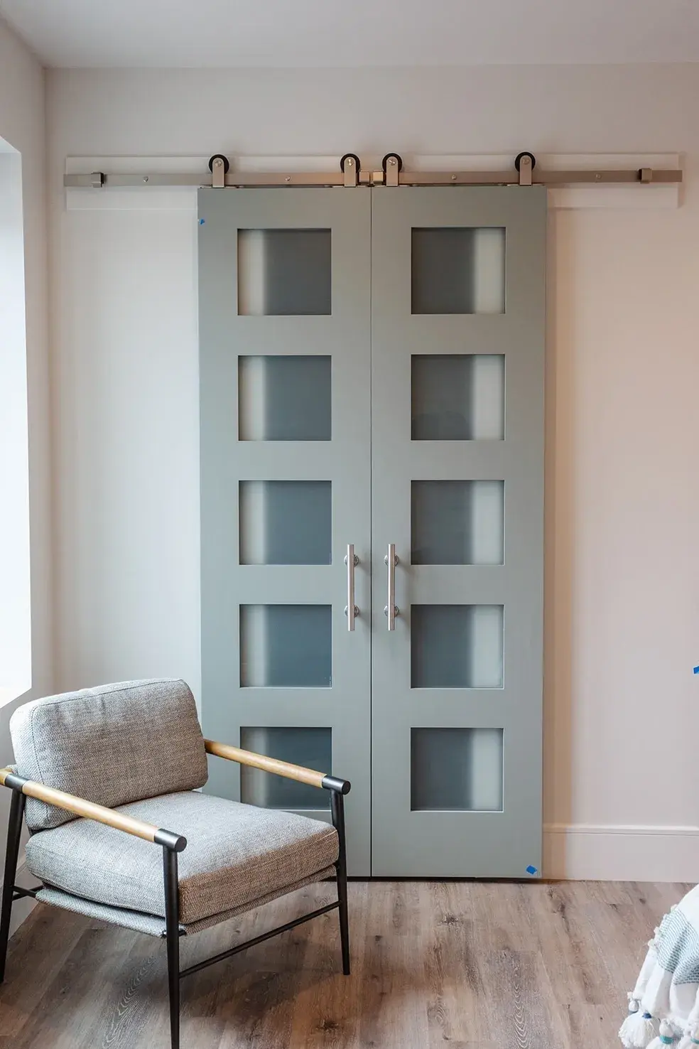 Modern gray barn doors with frosted glass panels in a contemporary custom home in Utah by E Builders
