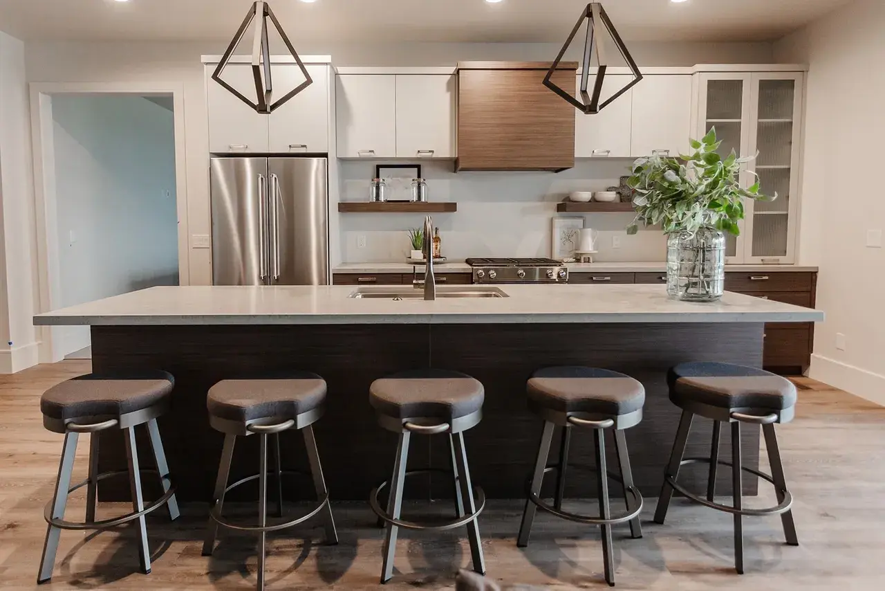 Stylish modern basement kitchen with dark wood cabinetry and a large island in a contemporary custom home in Utah by E Builders