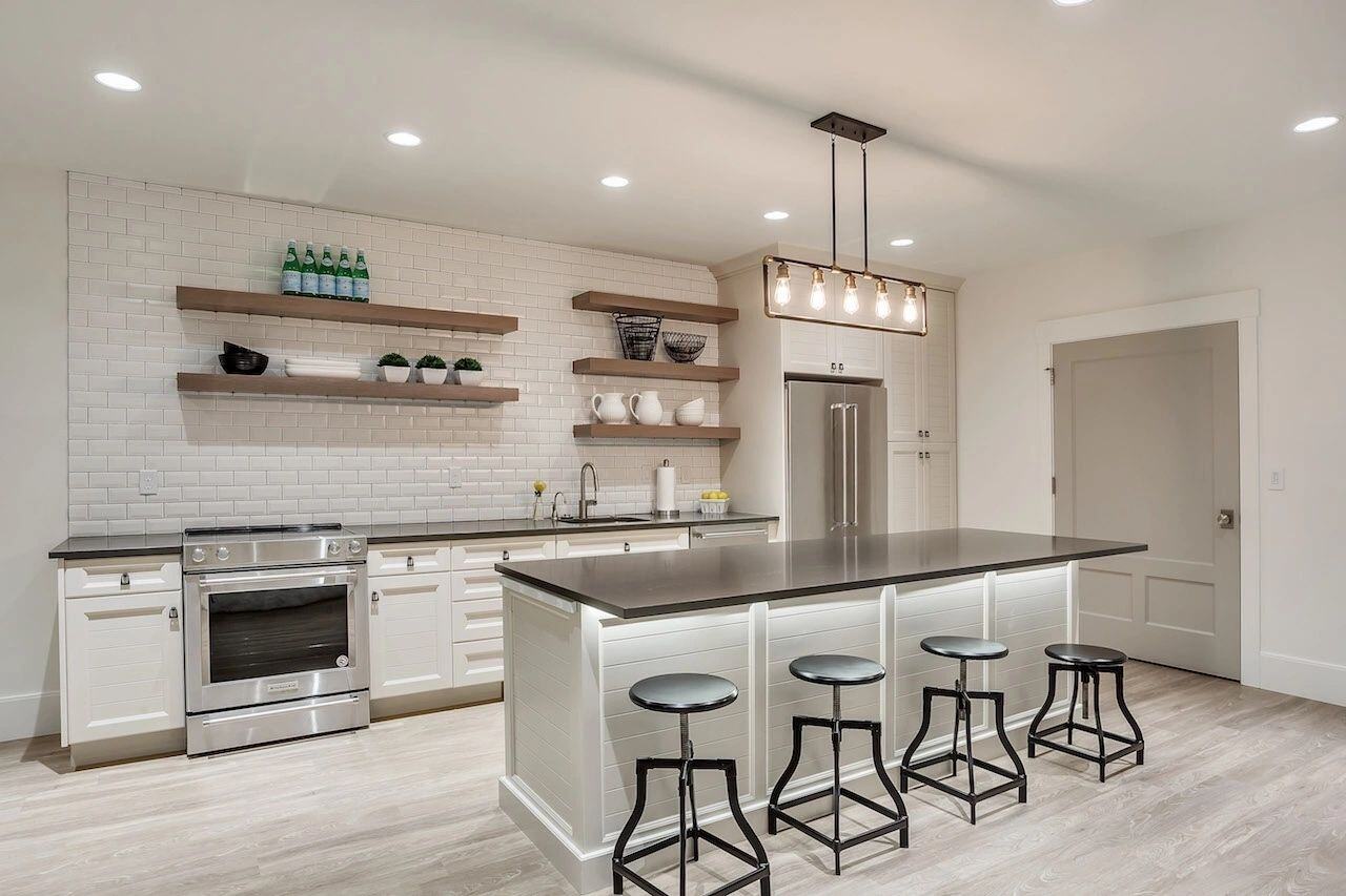 Contemporary white kitchen with subway tile backsplash in a custom home in Draper, UT by E Builders