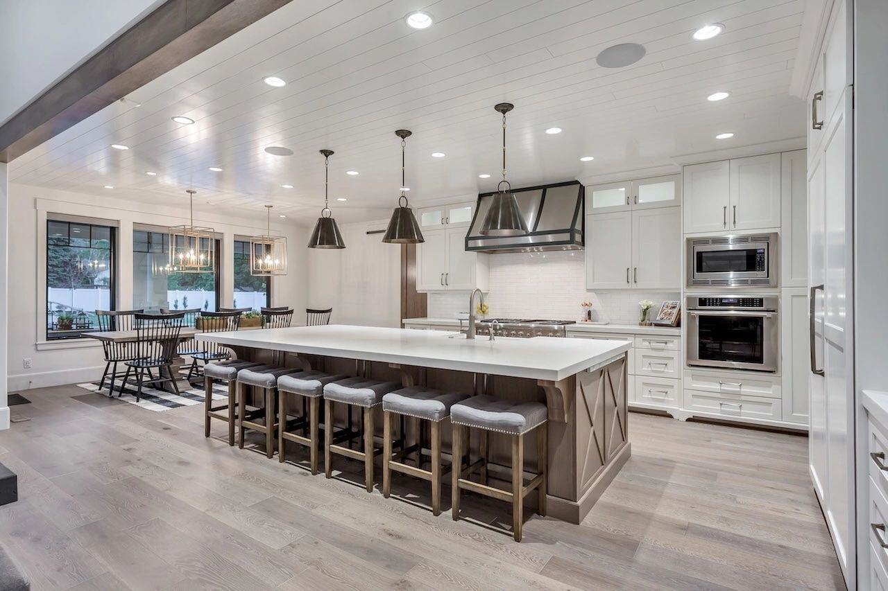 Gourmet kitchen with pendant lights and wood accents in a custom home in Draper, UT by E Builders