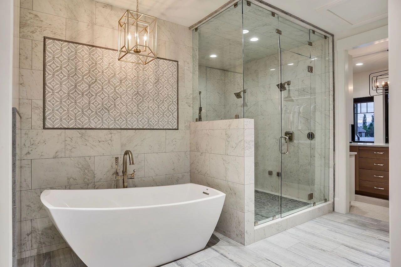 Marble tile bathroom with walk-in shower and freestanding tub in a custom home in Draper, UT by E Builders