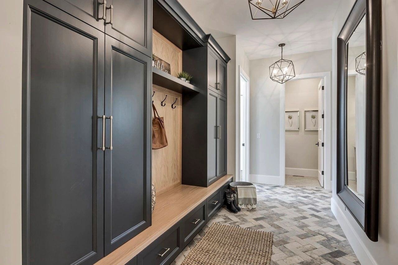 Mudroom hallway with dark built-ins and bench seating in a custom home in Draper, UT by E Builders
