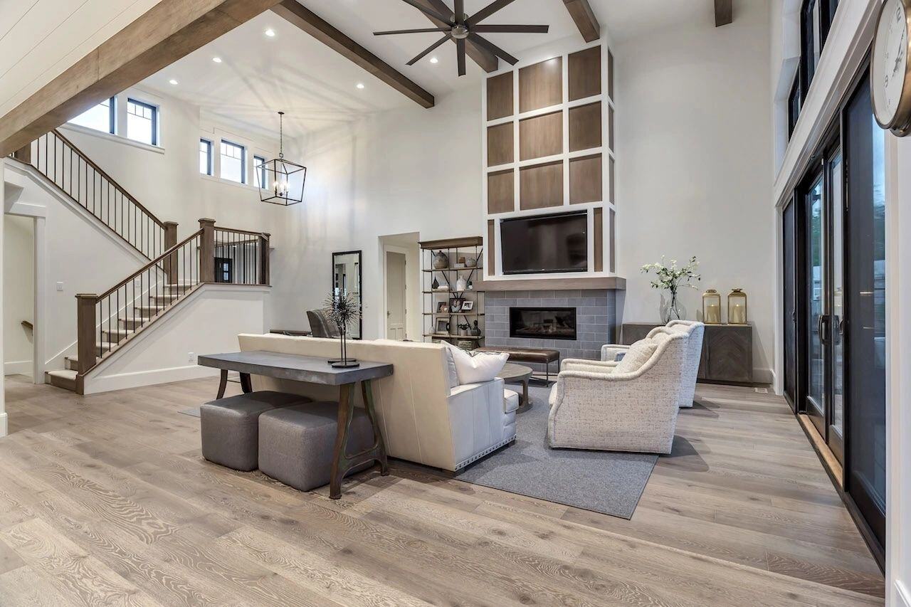 Open living space with vaulted ceiling and TV feature wall in a custom home in Draper, UT by E Builders