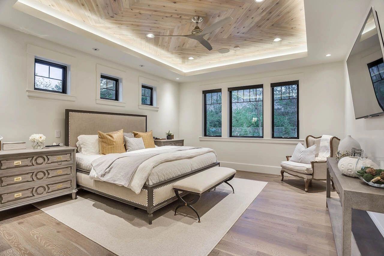 Spacious master bedroom with wood-accent ceiling in a custom home in Draper, UT by E Builders