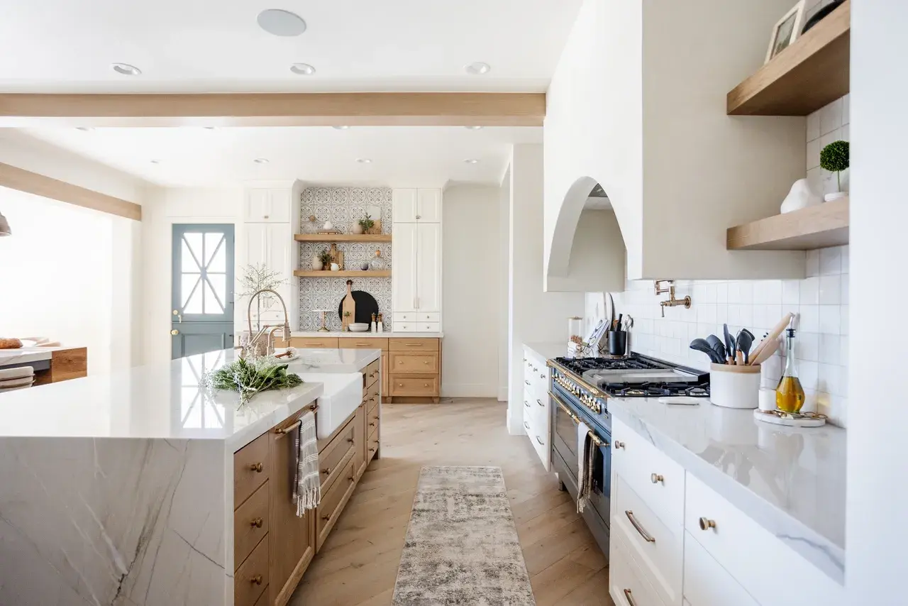 Beautifully designed kitchen with a blue Dutch door, custom shelving, and a statement range hood in a luxury custom home in Draper, Utah by E Builders