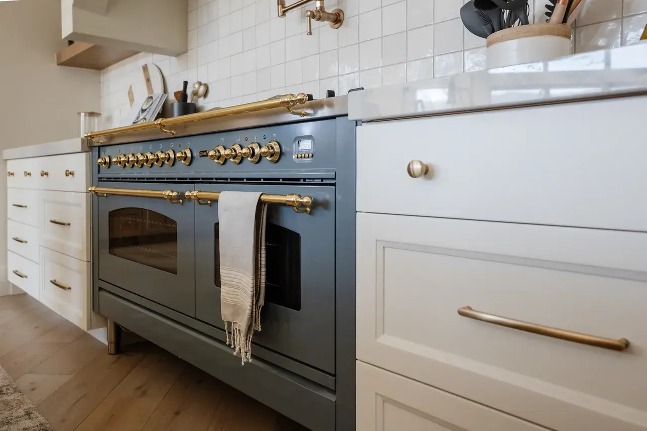 European-style blue range with brass accents and custom cabinetry in a luxury custom home in Draper, Utah by E Builders