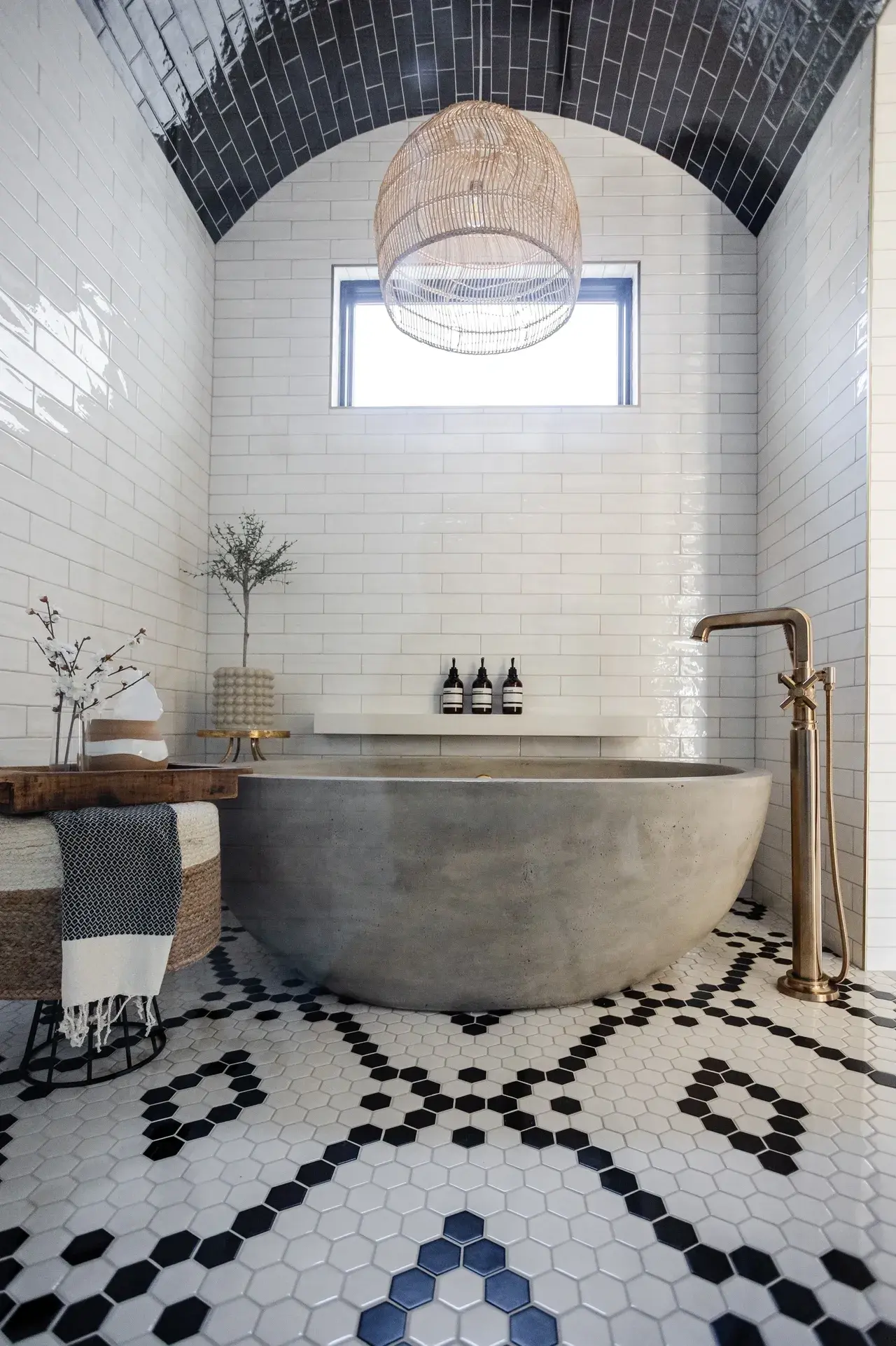 Luxurious bathroom with a custom soaking tub and black-and-white hexagonal tile flooring in a luxury custom home in Draper, Utah by E Builders