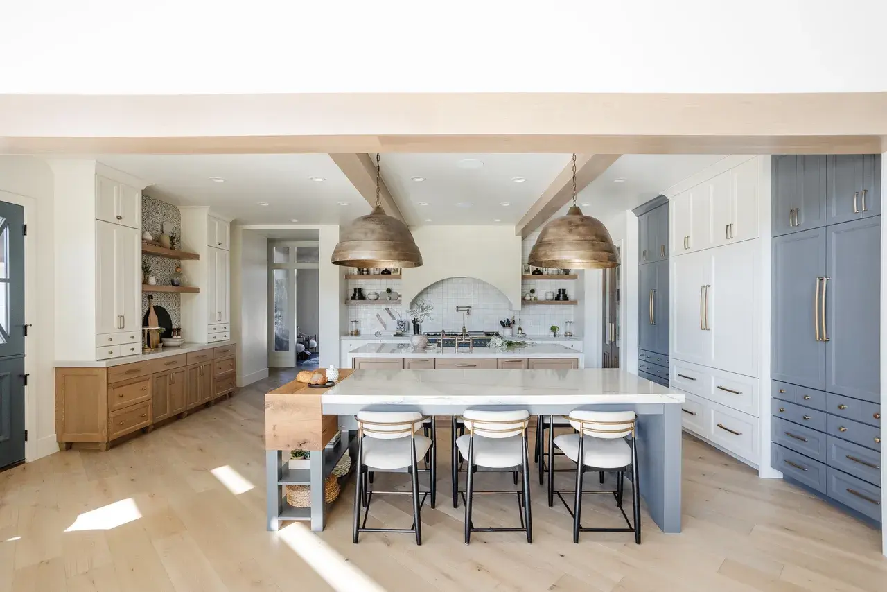 Modern farmhouse kitchen with white and blue cabinetry, open shelving, and a large center island in a luxury custom home in Draper, Utah by E Builders