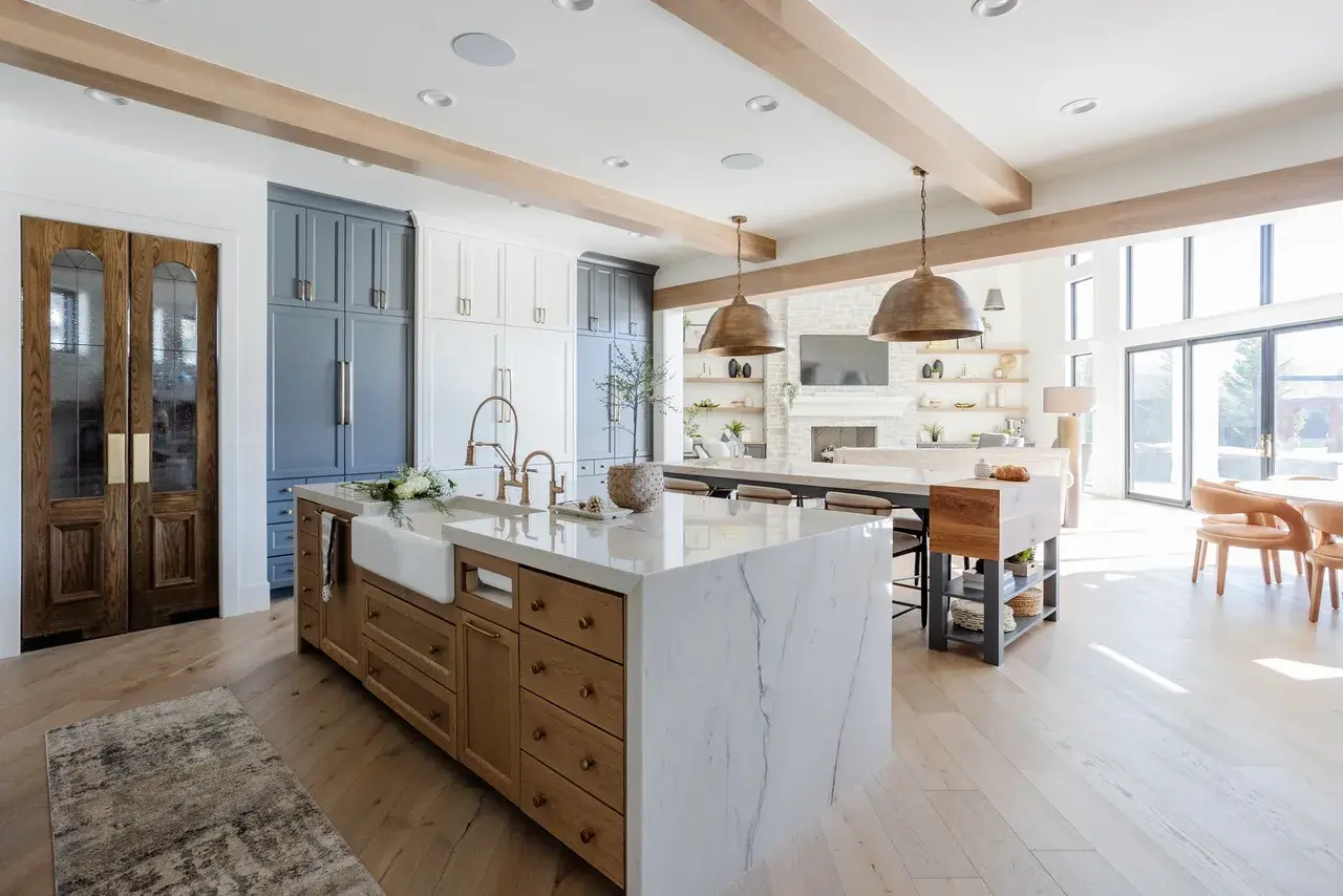 Modern rustic kitchen and living room with expansive windows, natural light, and custom finishes in a luxury custom home in Draper, Utah by E Builders