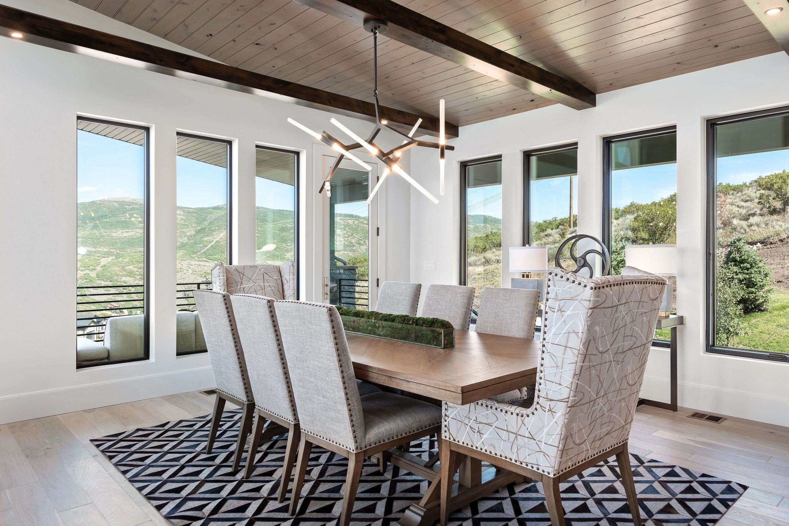 Dining room with panoramic windows and mountain views in a custom home in Park City, Utah by E Builders