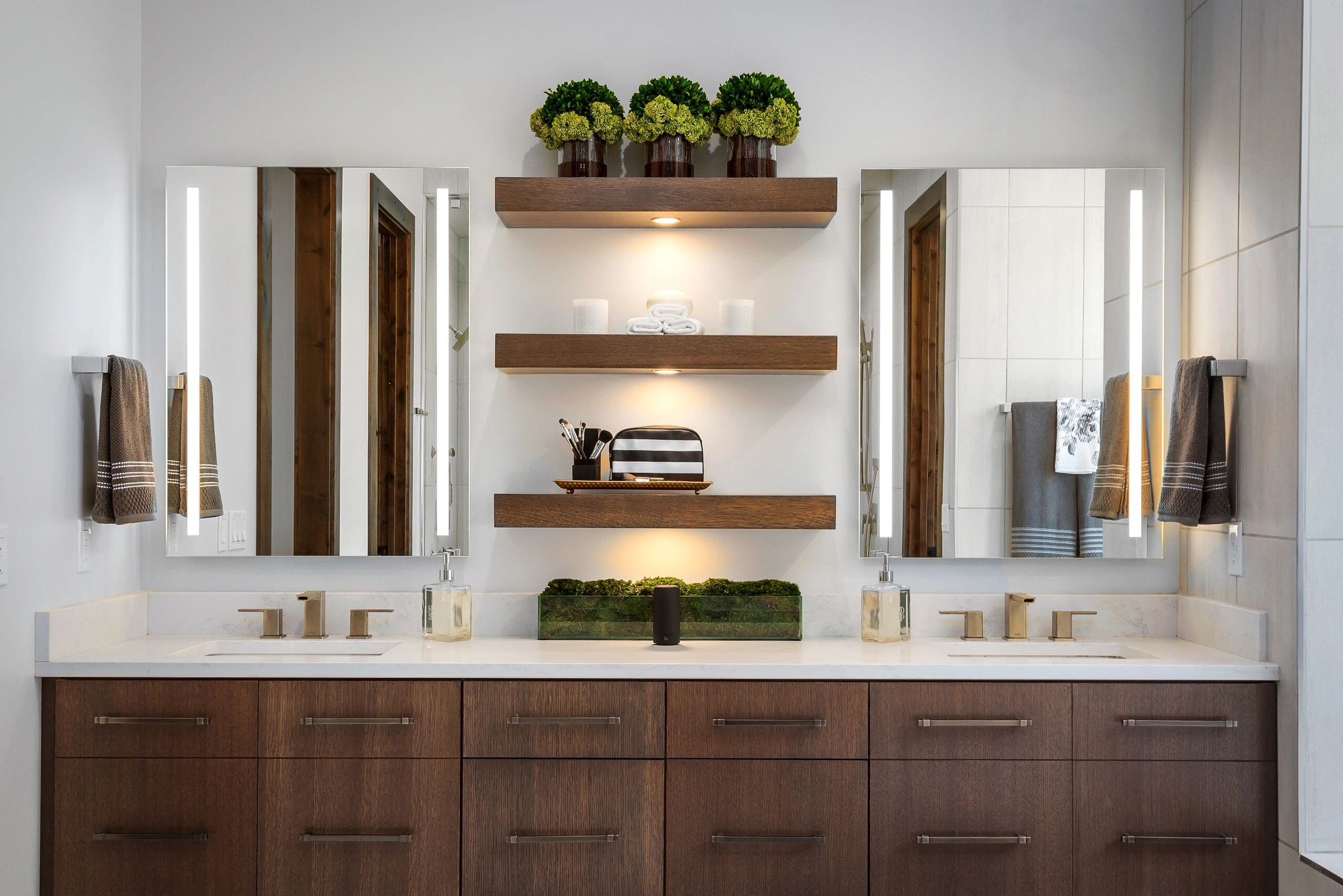 Dual vanity bathroom with floating shelves and greenery accents in a custom home in Park City, Utah by E Builders
