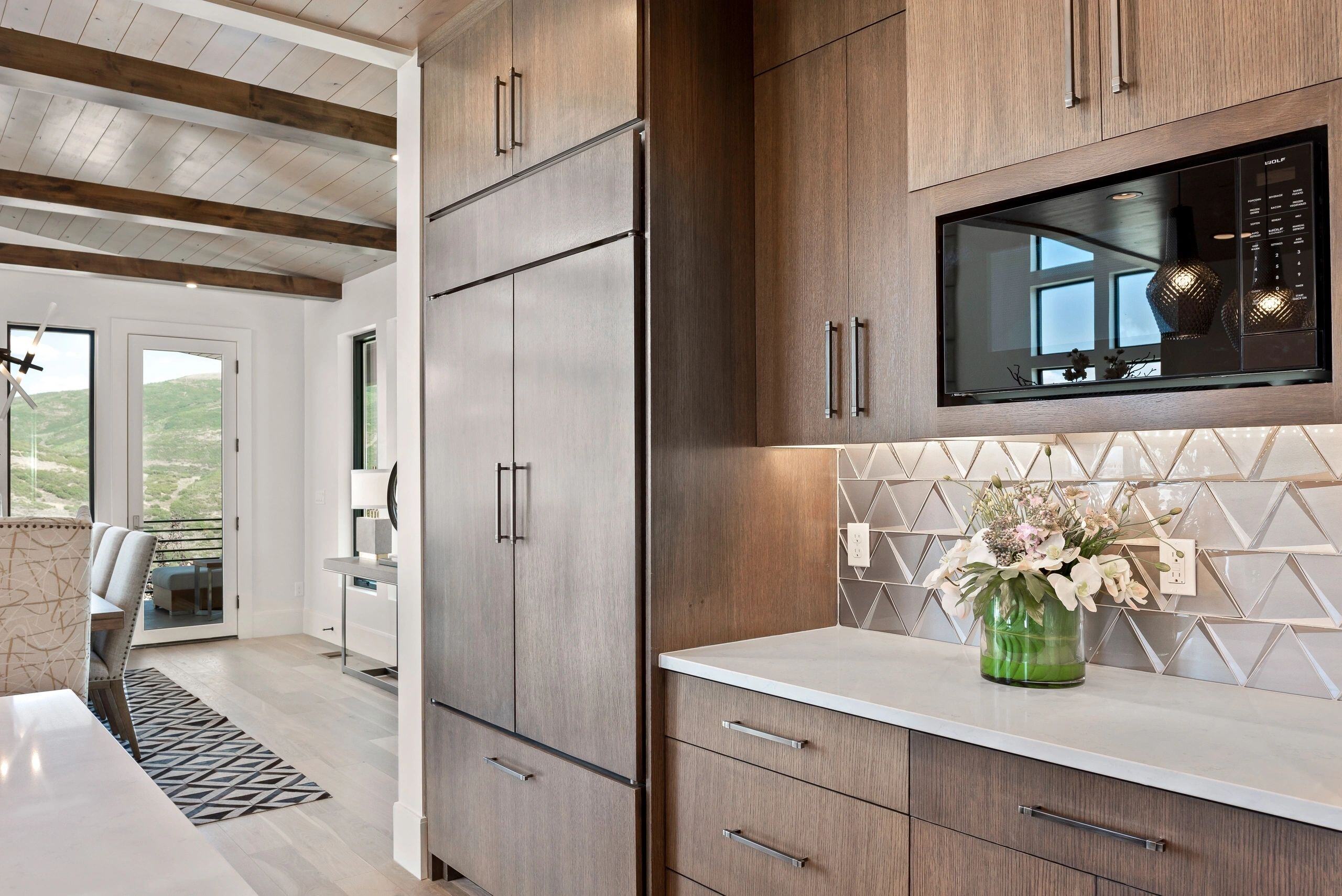 Kitchen corner with built-in microwave and flower arrangement in a custom home in Park City, Utah by E Builders