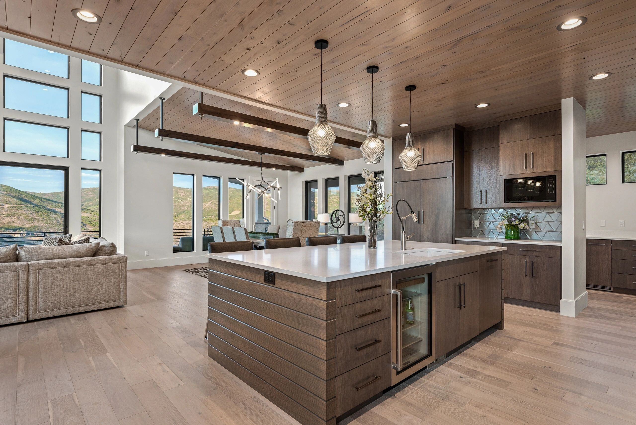 Kitchen island with bar seating and pendant lighting in a custom home in Park City, Utah by E Builders