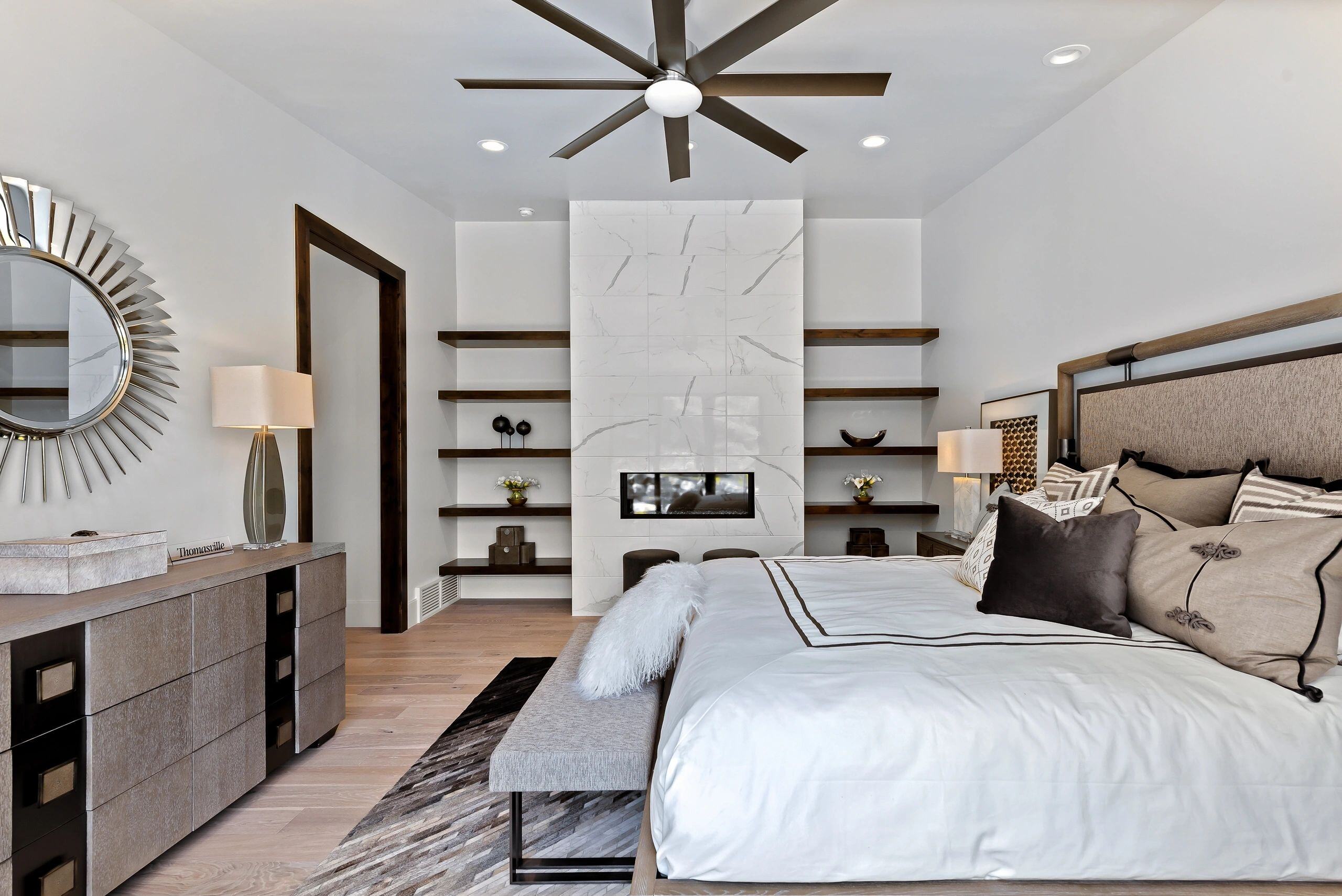 Luxury bedroom design with built-in shelving and a textured headboard in a custom home in Park City, Utah by E Builders
