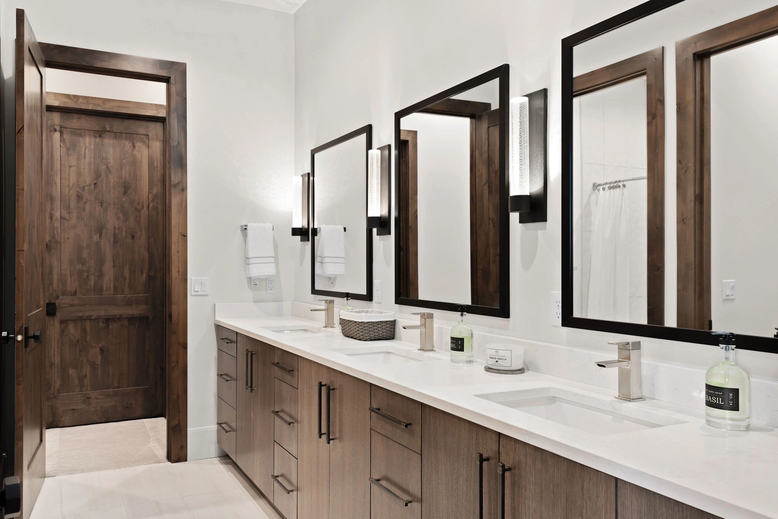 Modern bathroom with dual sinks and rustic wood accents in a custom home in Park City, Utah by E Builders