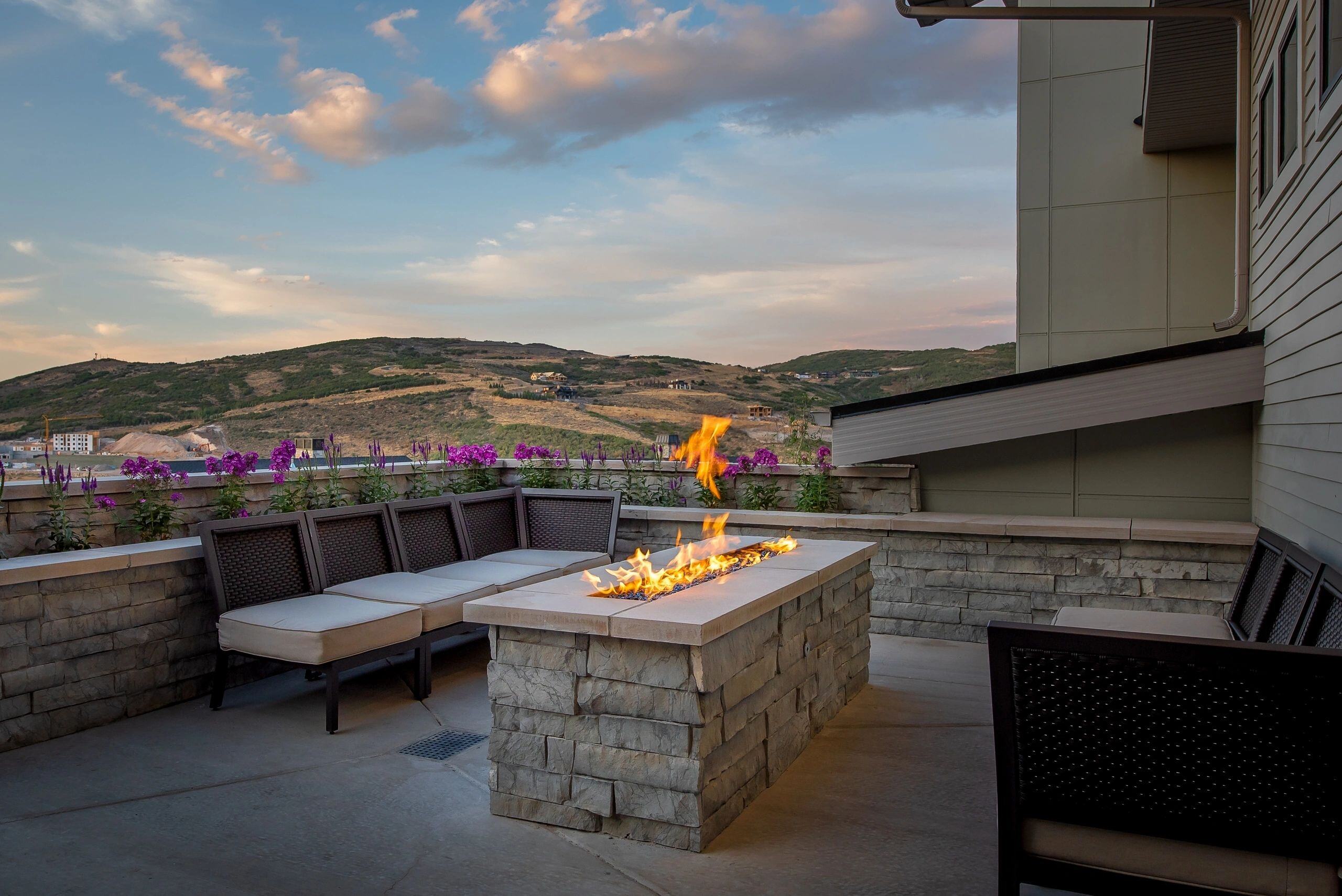 Outdoor patio with modern fire pit and mountain views in a custom home in Park City, Utah by E Builders