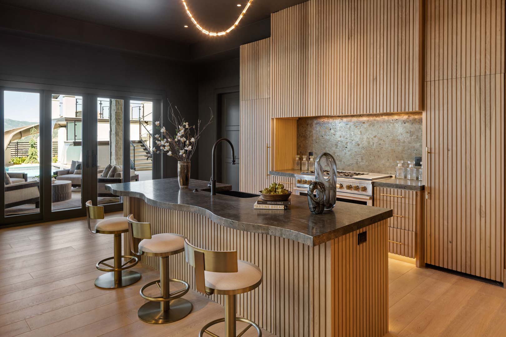 Basement kitchen with modern wood textures in custom home Room with a View featured in the 2025 Utah Valley Parade of Homes by E Builders