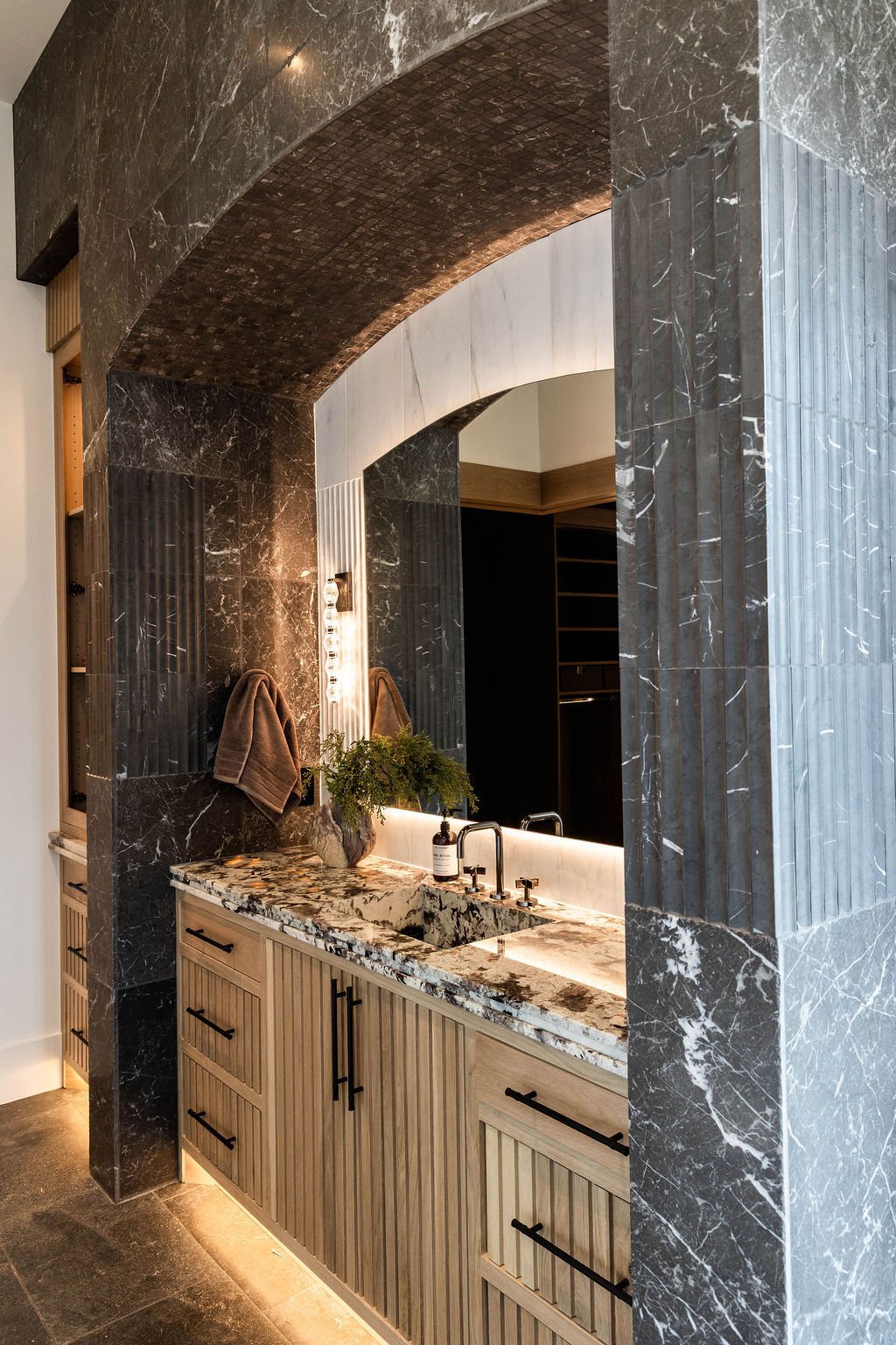 Bold and elegant vanity design with detailed woodwork and dark tile in the Room with a View custom home featured in the 2025 Utah Valley Parade of Homes by E Builders