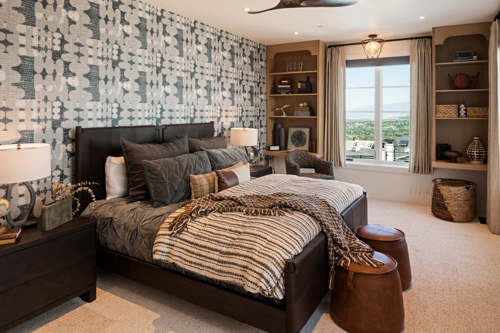 Contemporary bedroom with patterned accent wall and built-in shelving in custom home Room with a View featured in the 2025 Utah Valley Parade of Homes by E Builders