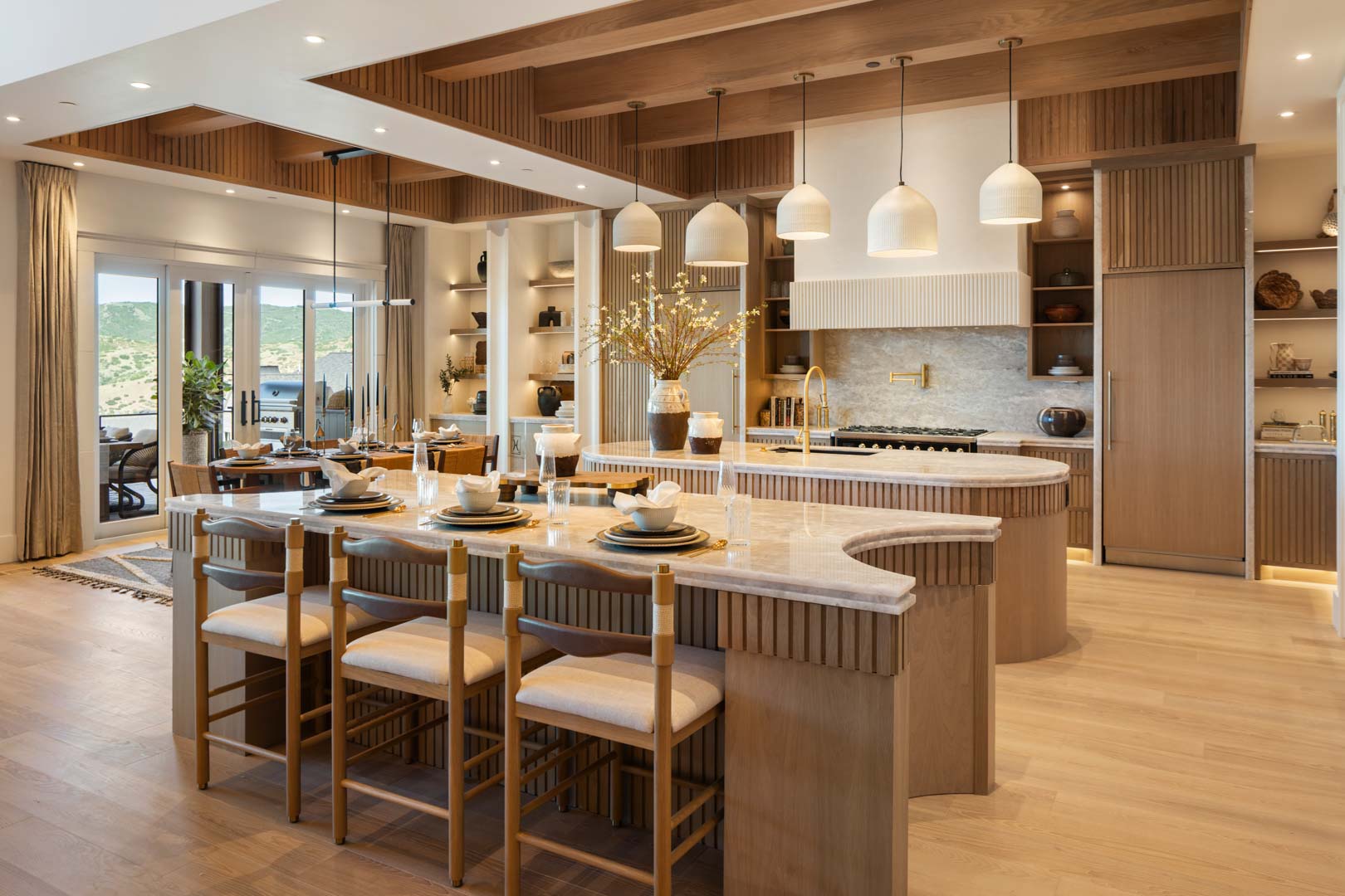 Designer kitchen with double island and pendant lights in custom home Room with a View featured in the 2025 Utah Valley Parade of Homes by E Builders